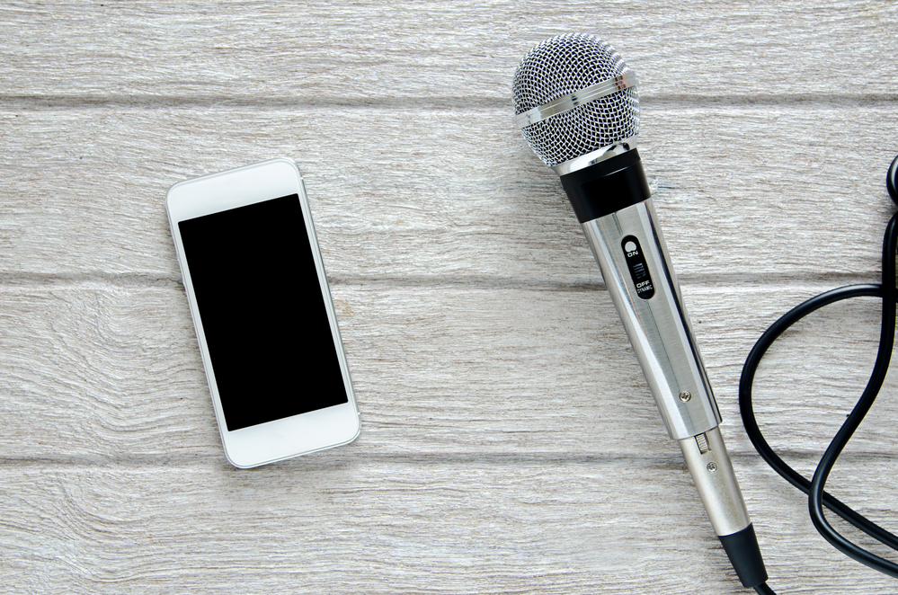 microphone and smart phone on white wooden table